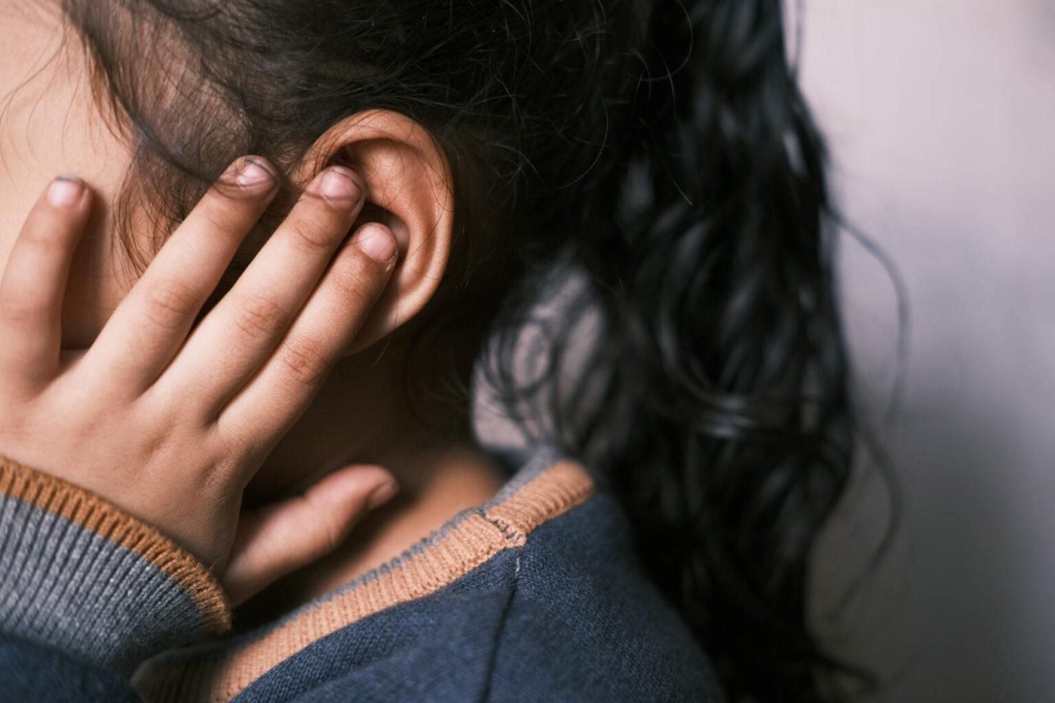 girl covering ear